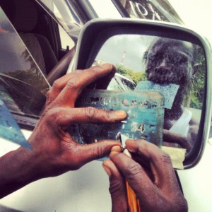 A man engraving a side mirror on a newly imported car. Photo: Daniel Hayduk